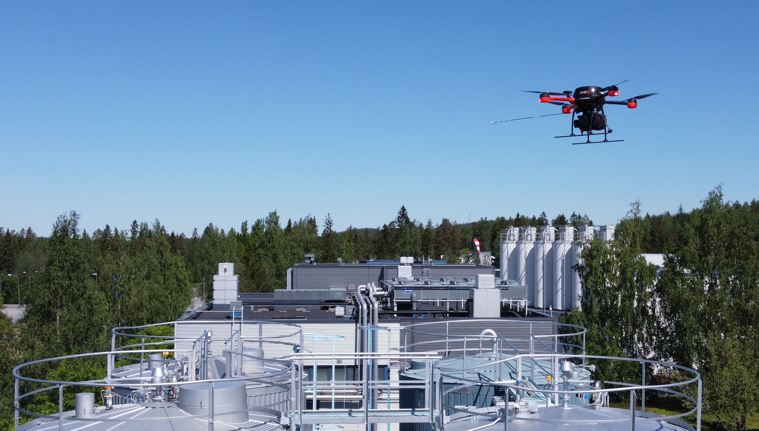 A drone flying on top of tank tops on a process industry site.