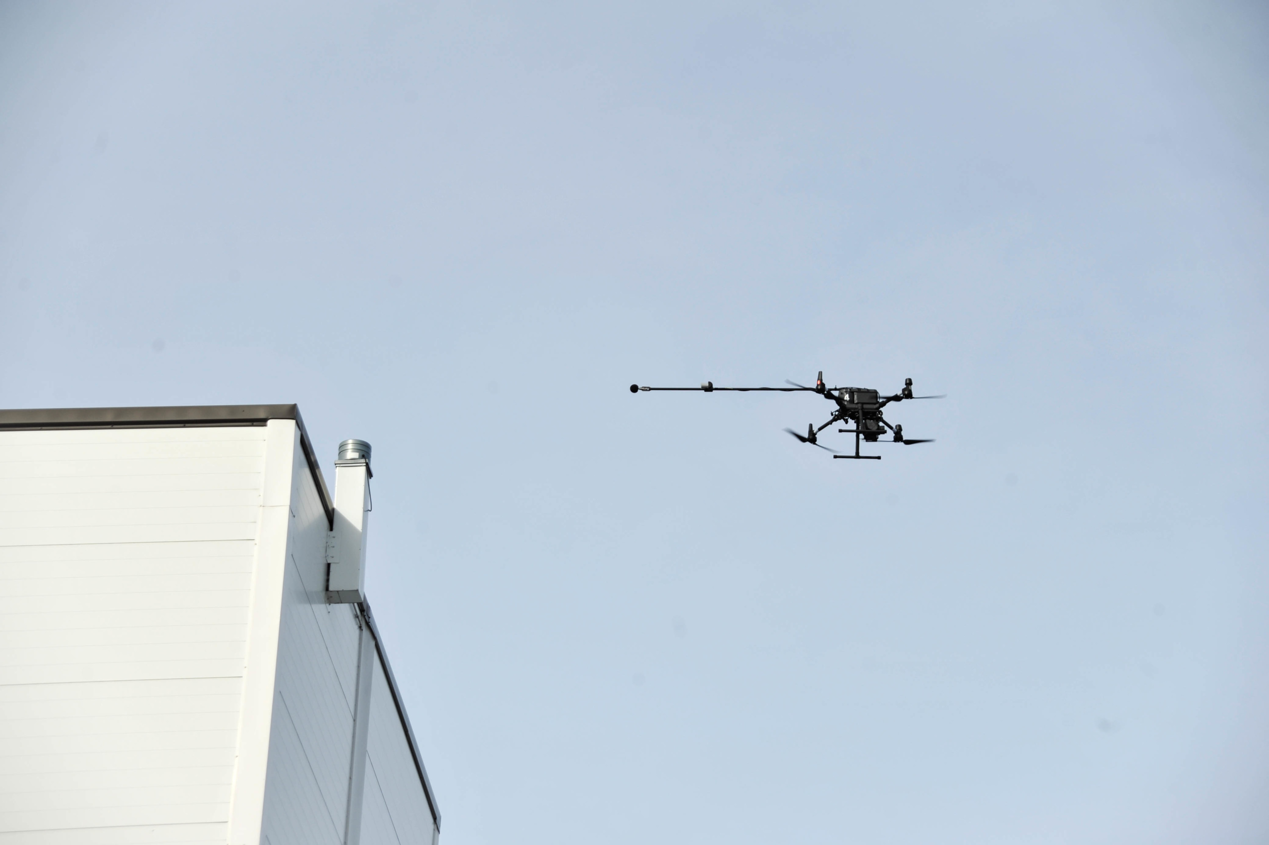 A drone hovering close to a process plants roof top and a noise source.