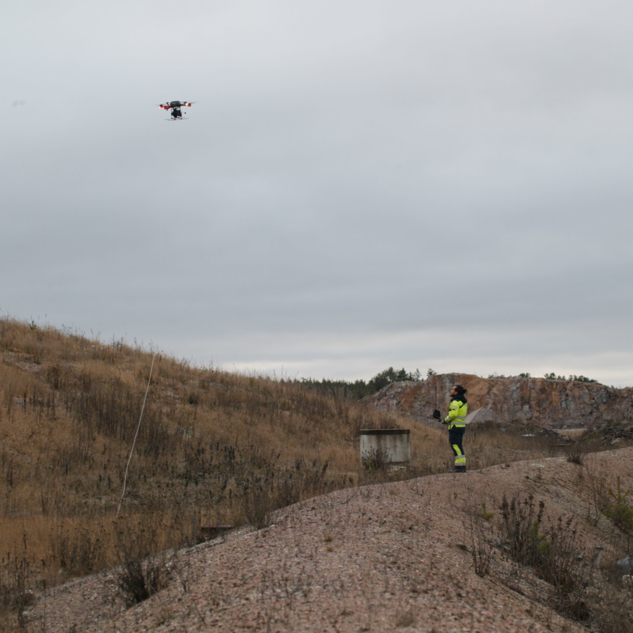 Aeromon field engineer flying a drone over a landfill.
